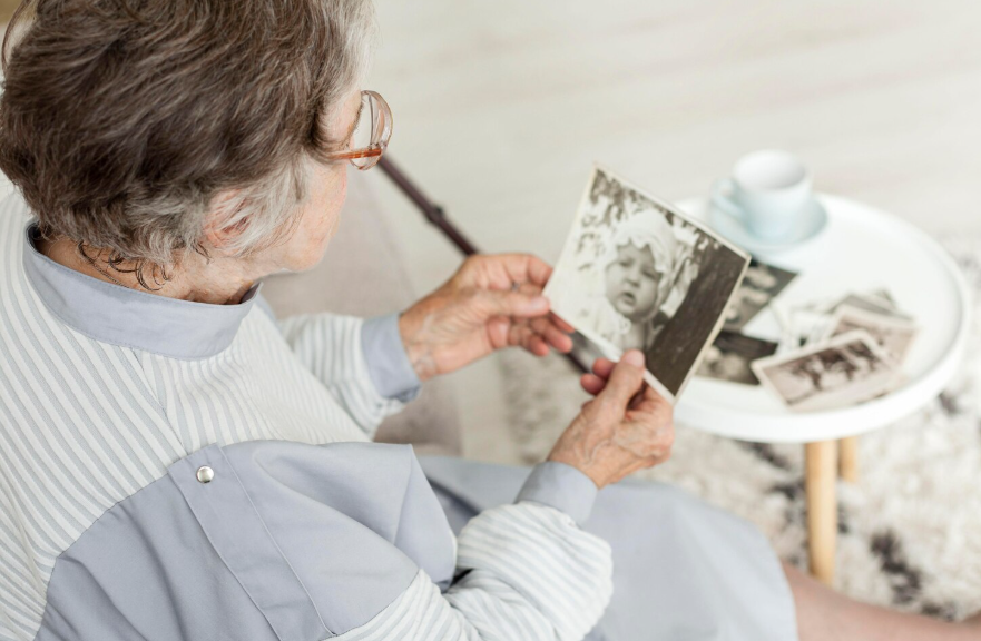 Older woman viewing childhood photos showing why time feels faster as you get older.