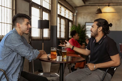 Two people talking at a café showing why people are curious about others.