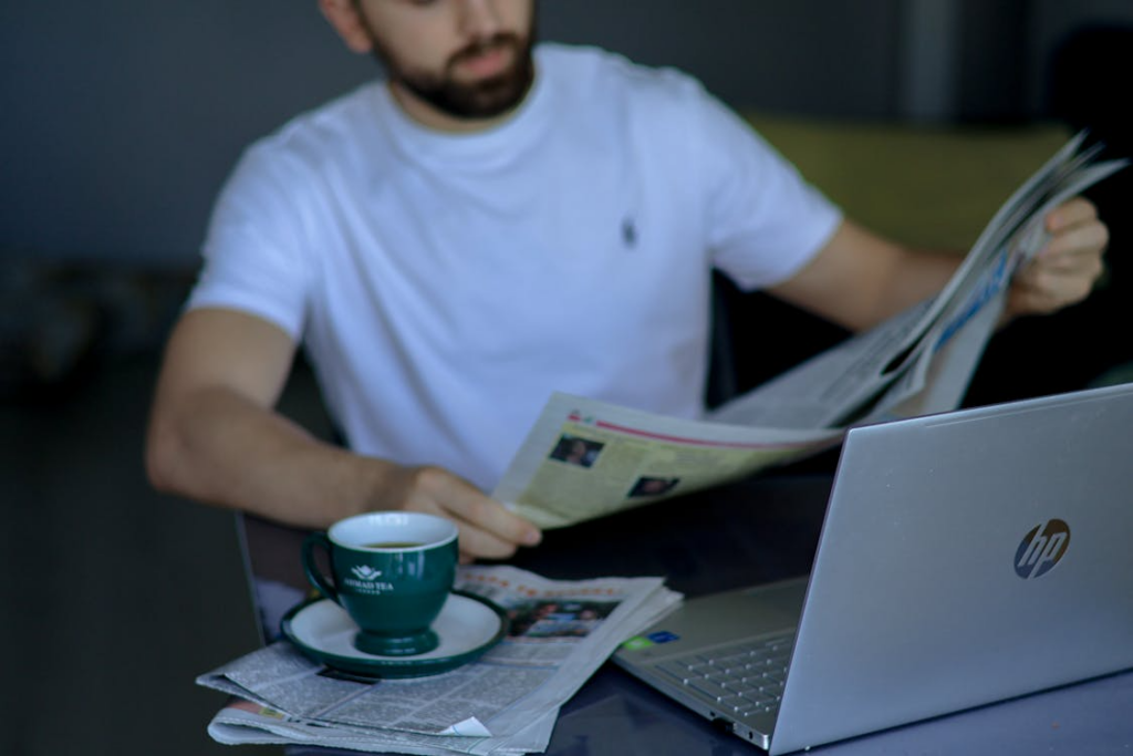 Person reading news with coffee showing why people check news in the morning.