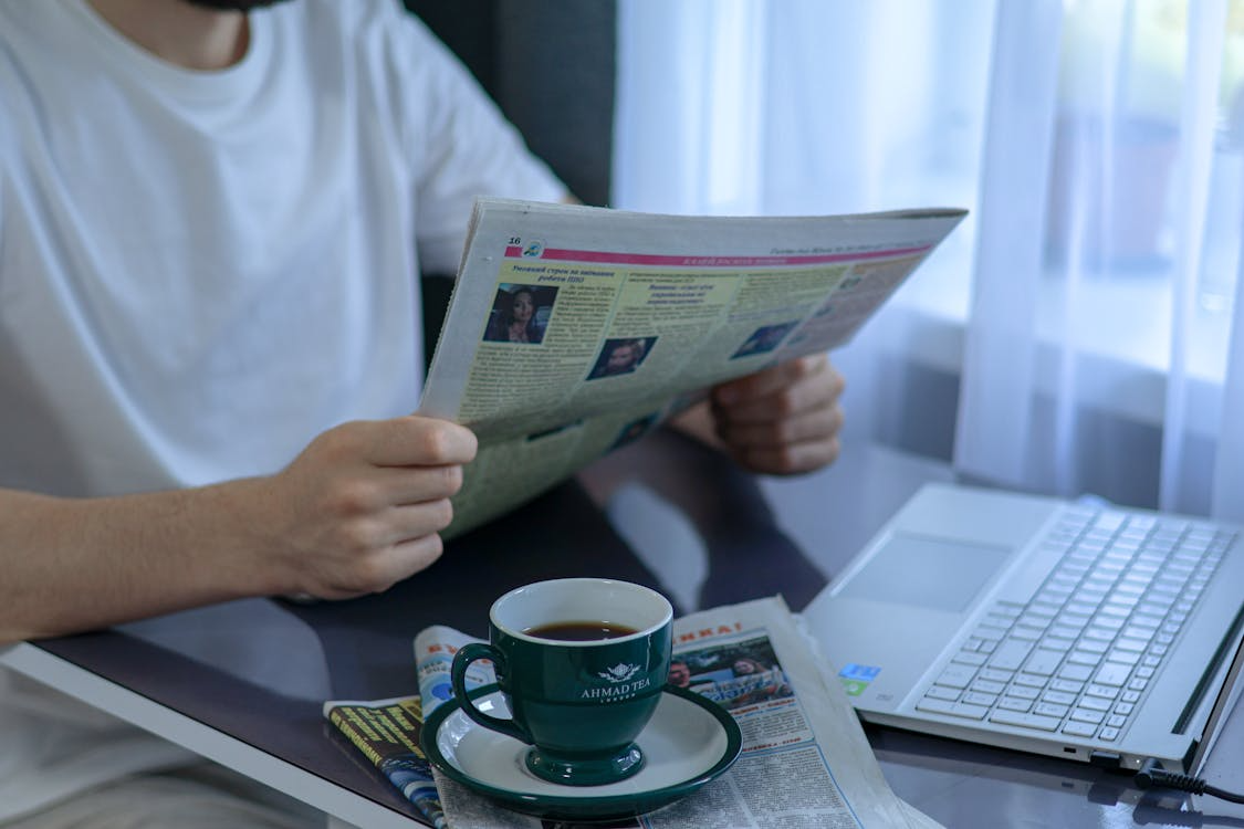 Man reading a newspaper, showing how people consumed news before smartphones.