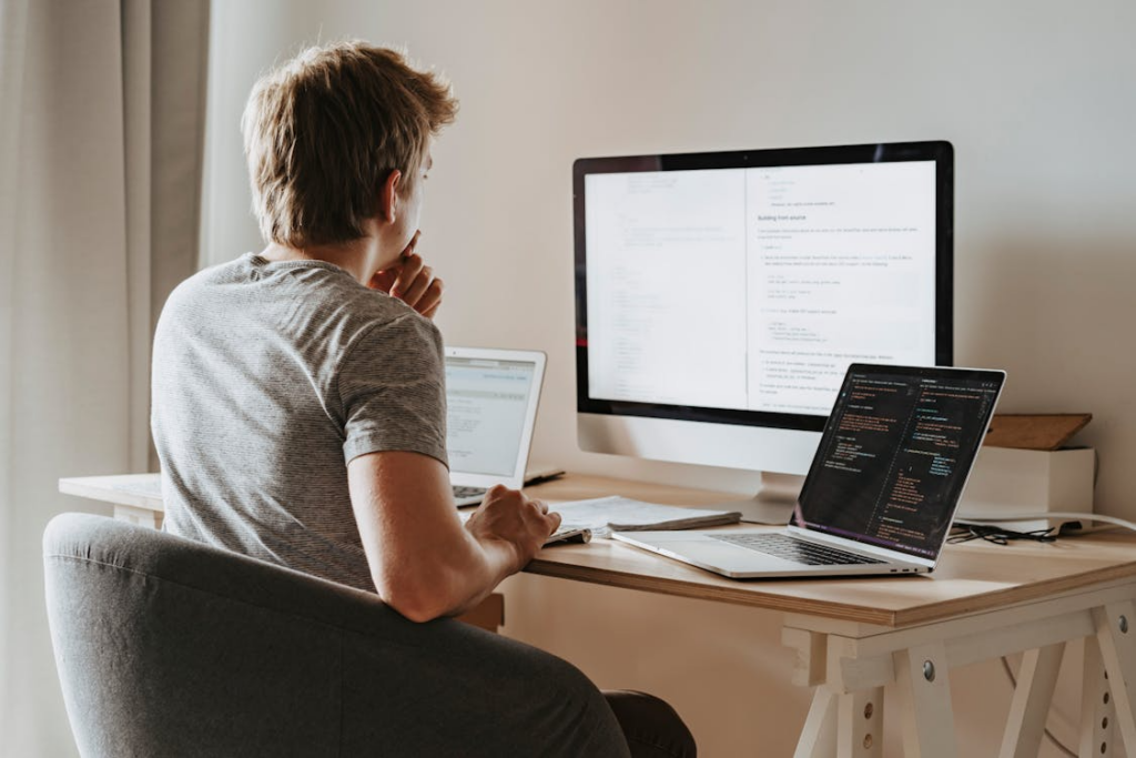 Man using multiple screens illustrating the difference between information overload vs being informed.