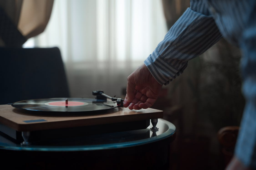 Person enjoying a vinyl record player showing why analog hobbies are returning.