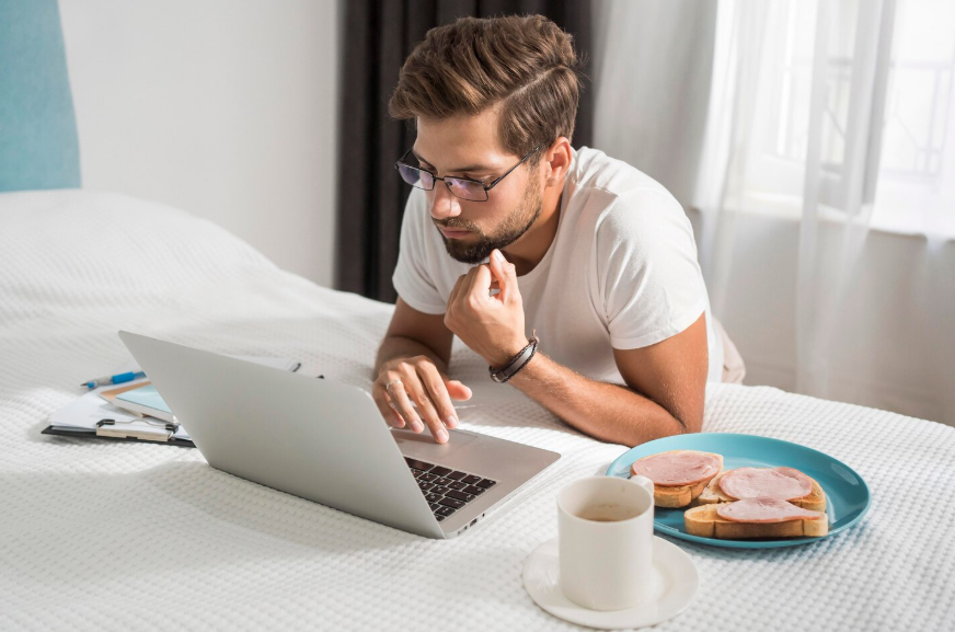 Man reading on a laptop at breakfast showing why morning newsletters are popular.