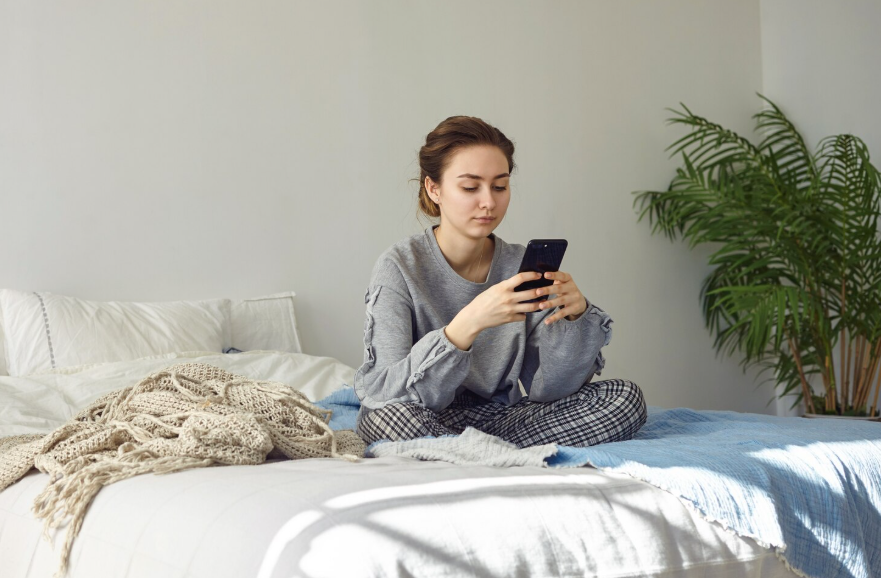 Woman checking her phone could affect her morning productivity routine.