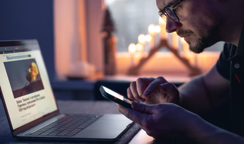 Man checking online headlines and learning how to spot clickbait.